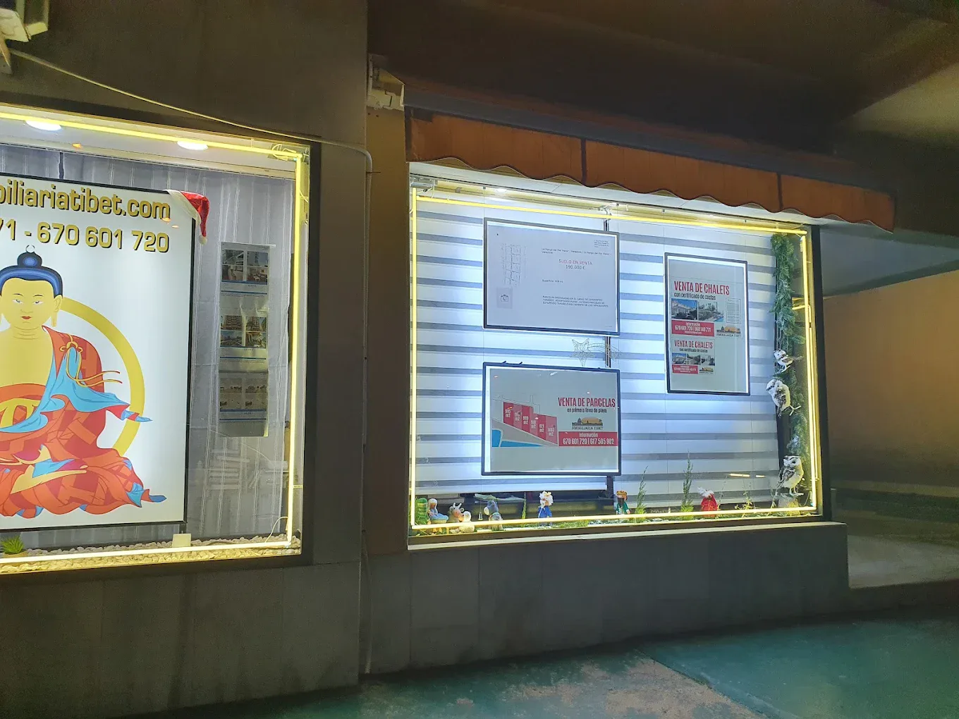 Escaparate nocturno con anuncios de propiedades de Inmobiliaria Tibet