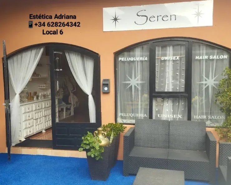 Fachada de Estética Adriana en el Local 6 de la Gran Vía de La Manga, con cortinas blancas y sofá de exterior en la entrada
