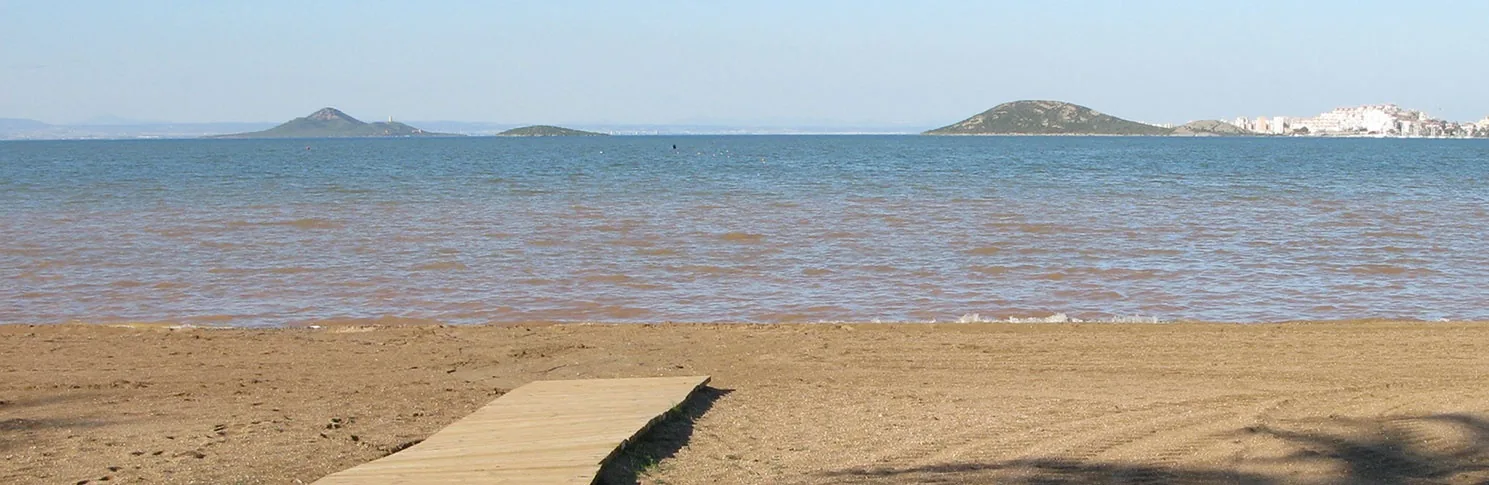 Aguas someras y en calma del Mar Menor desde Playa Honda, con las islas y la sierra al fondo