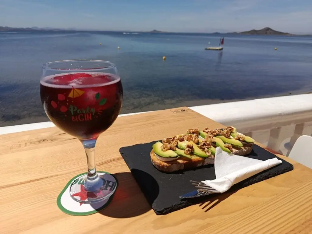 Copa de vino y tabla de aperitivo con vistas al Mar Menor en Amonet
