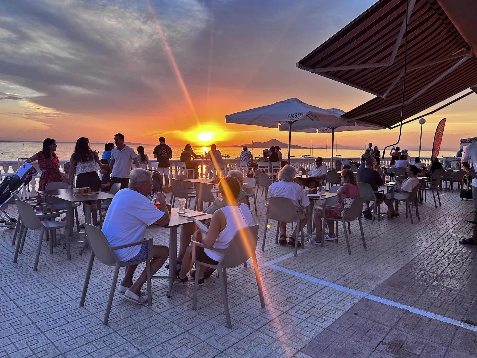 Terraza de Amonet al atardecer con clientes junto al Mar Menor