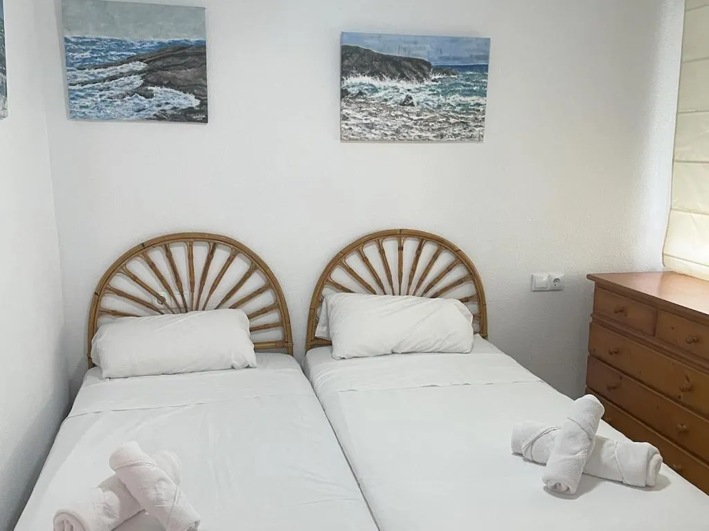 Dormitorio del apartamento con dos camas individuales y cabeceros de mimbre