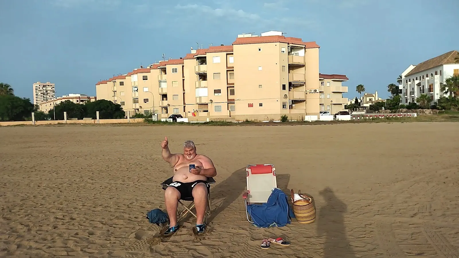 Bañistas frente al edificio de Apartamentos Altair en la playa de La Manga