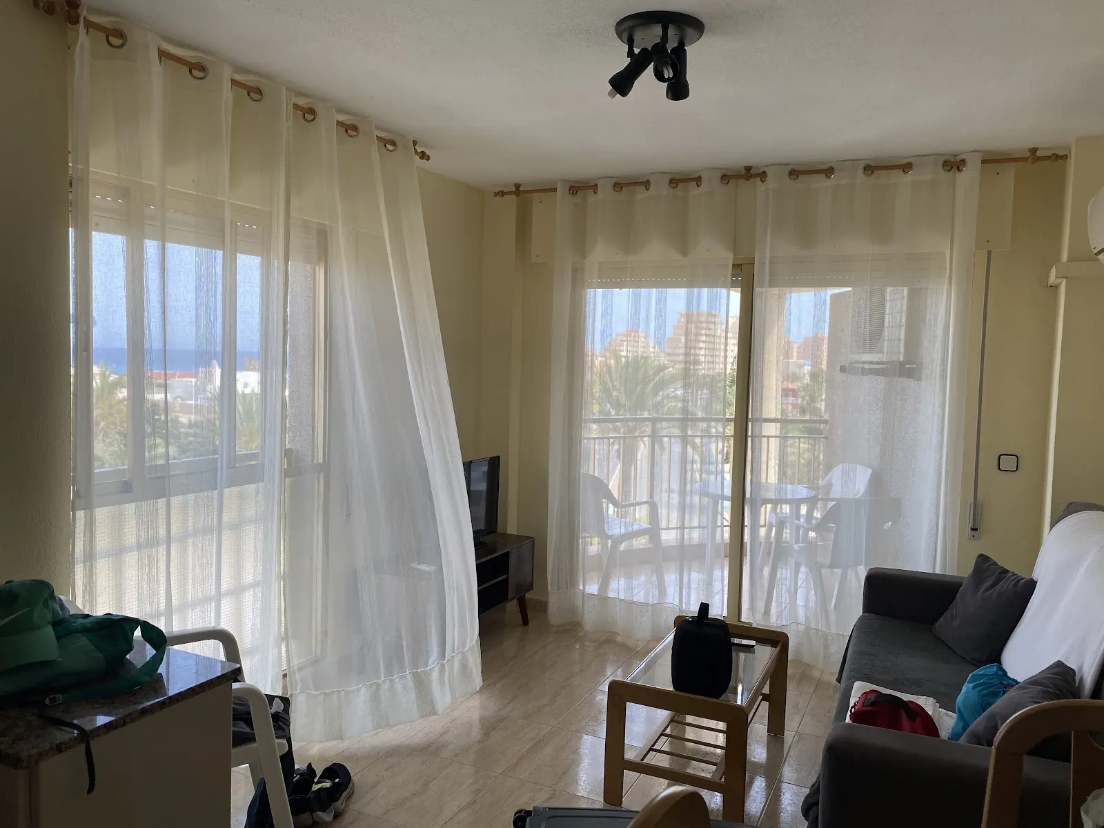 Salón con cortinas y vistas al mar en un apartamento de Olympia Center