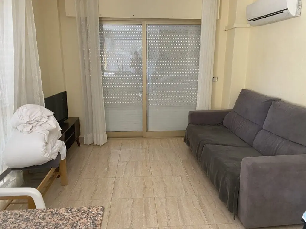 Salón con sofá y aire acondicionado en un apartamento de Olympia Center