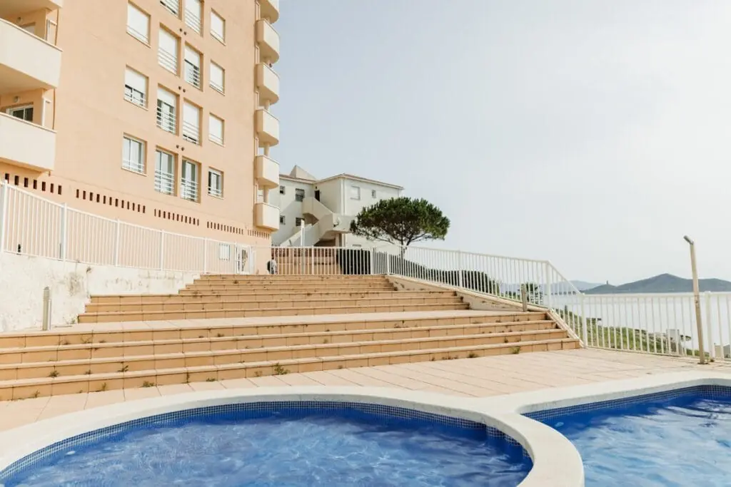 Piscina y escalinata de acceso en el edificio de Apartamentos Vistamar
