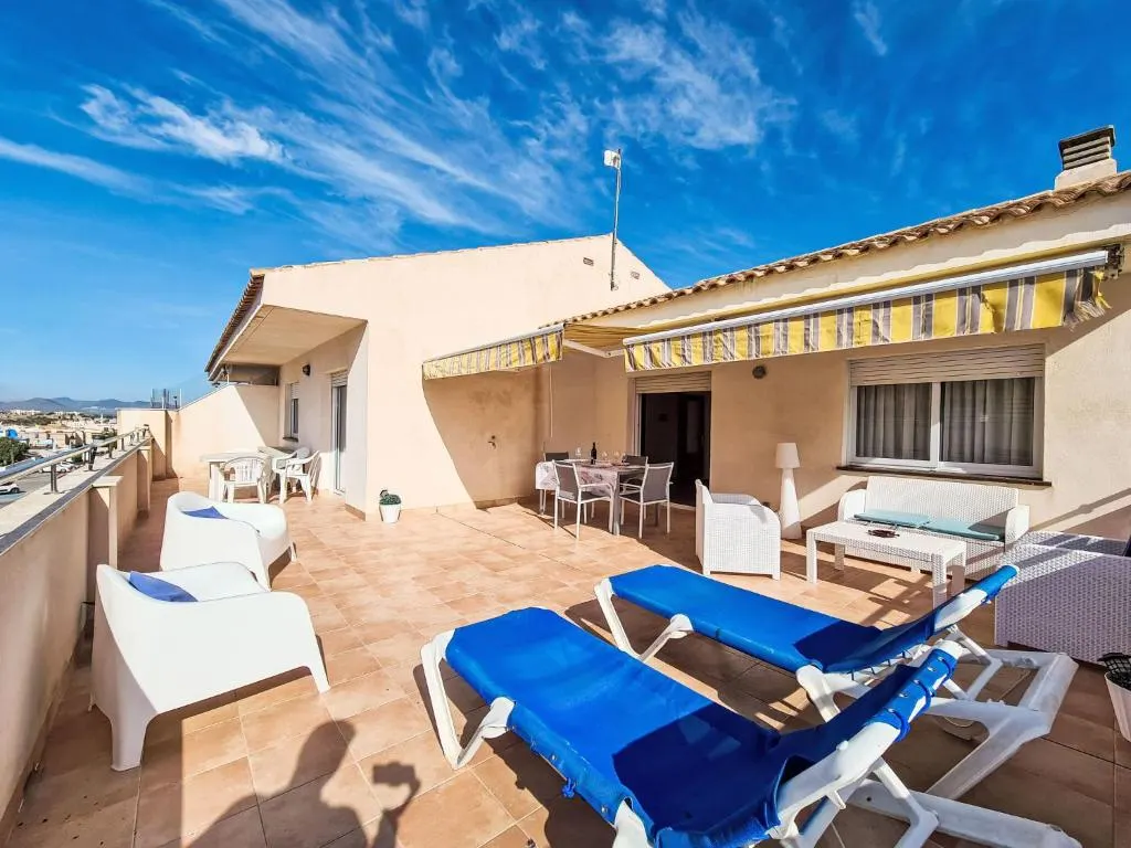 Terraza en la azotea del apartamento La Galera con tumbonas azules