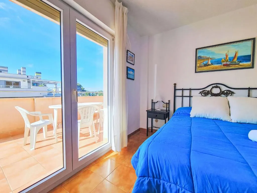Dormitorio con cuadro de veleros en el apartamento La Galera