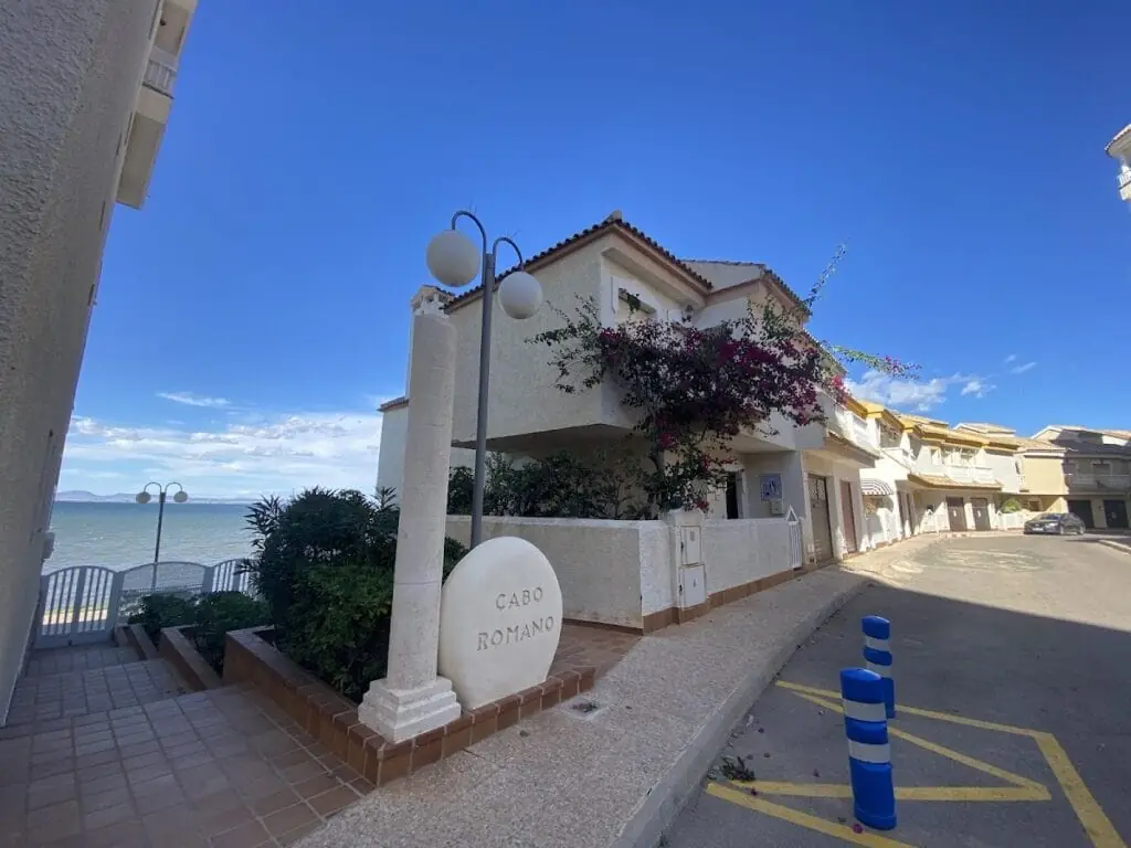 Entrada a la Urbanización Cabo Romano con su rótulo distintivo