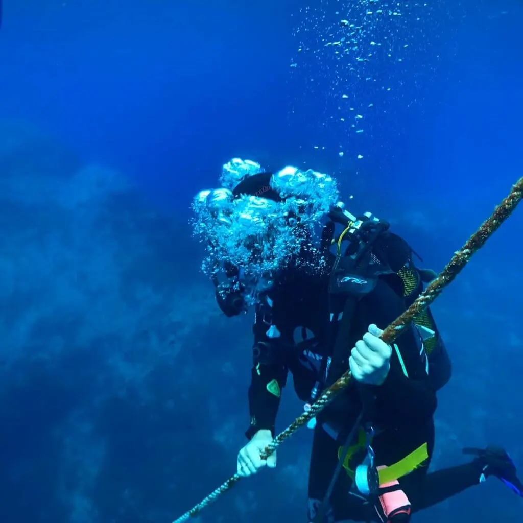 Buceador de Balky Sub sujeto a un cabo de descenso bajo el agua