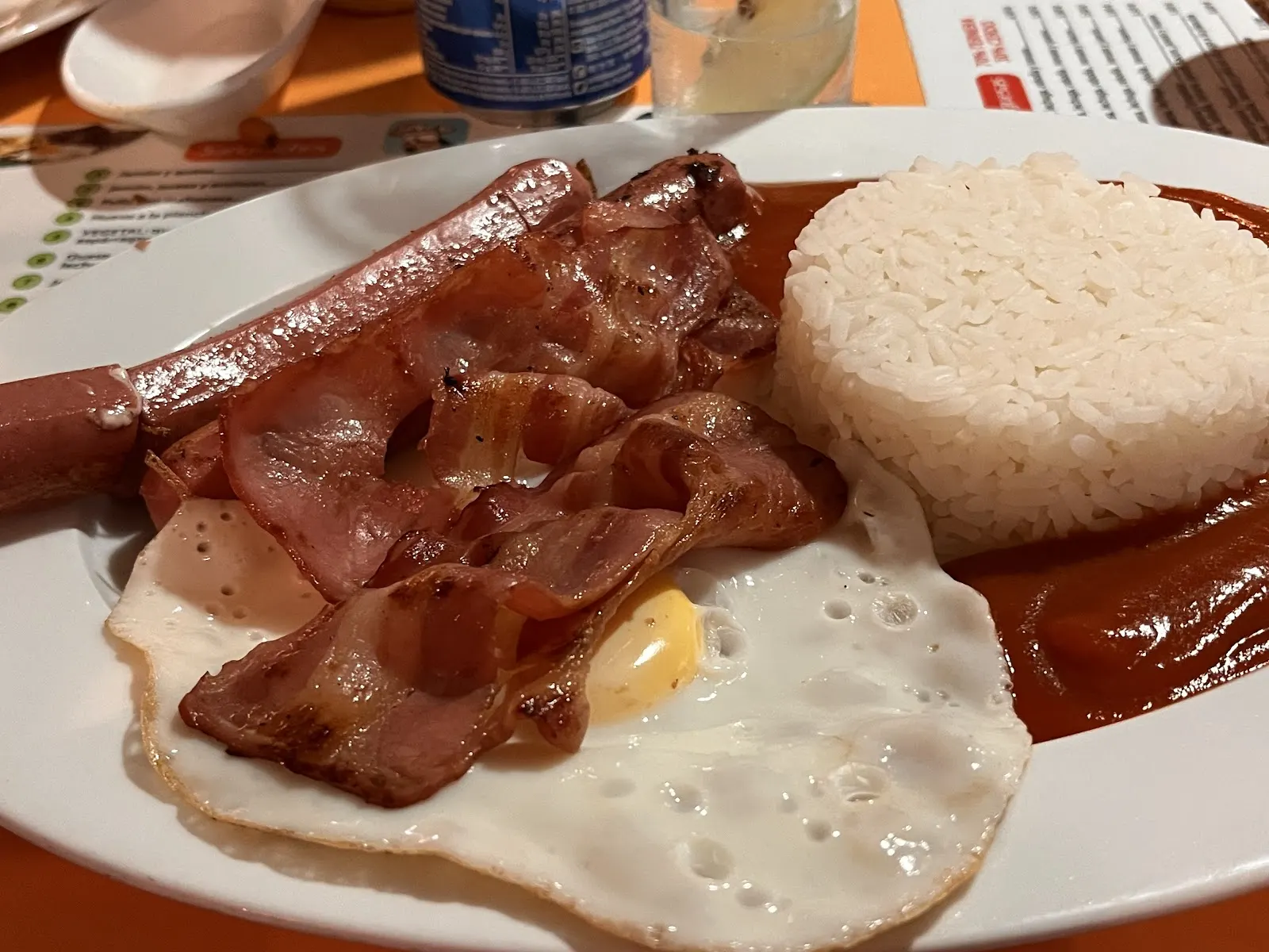 Plato combinado con huevo frito, bacon, salchicha y arroz en Bar Mortadelo