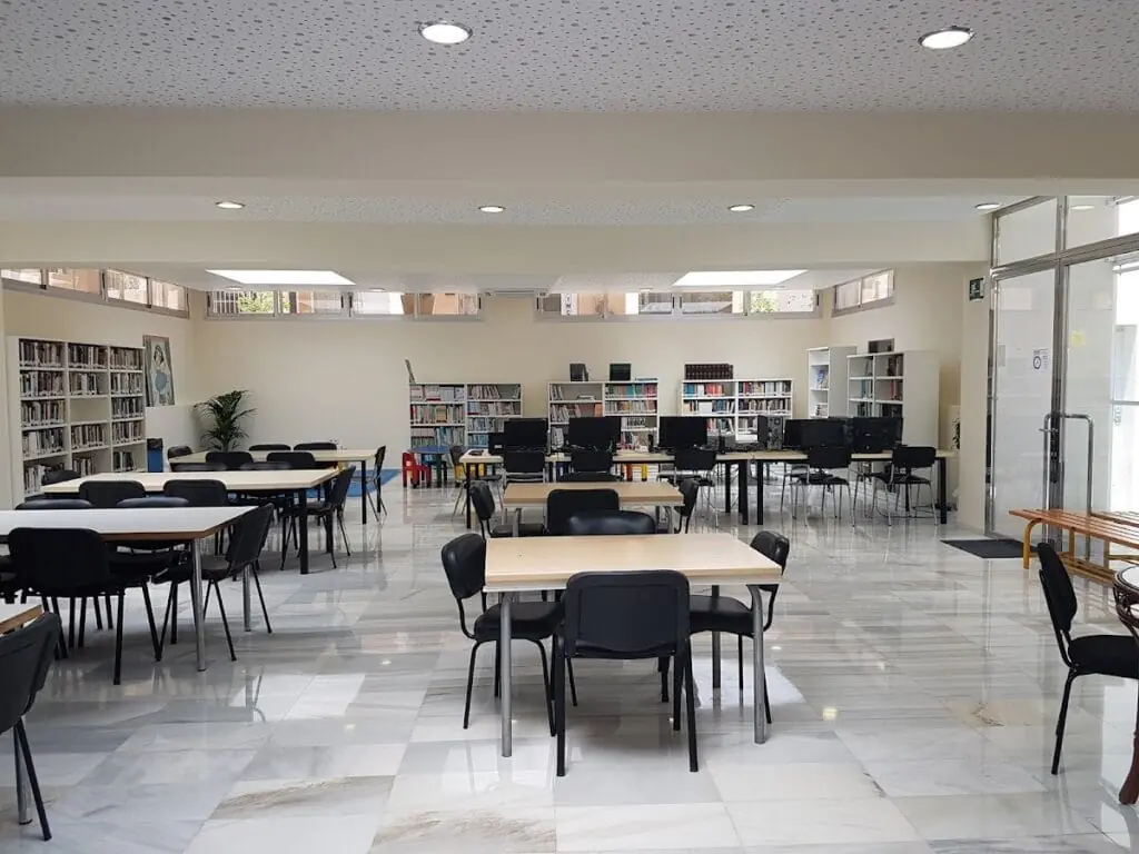 Sala de lectura con estanterías y mesas de la Biblioteca de La Manga (San Javier)