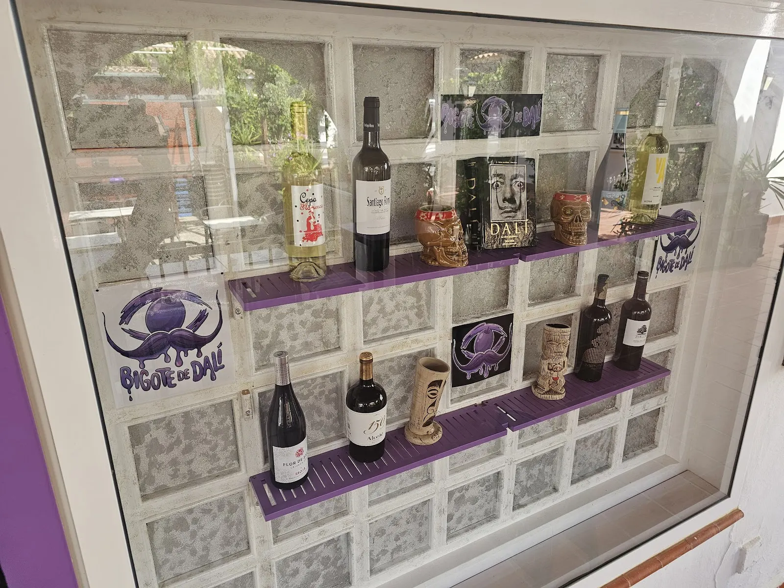 Vitrina con botellas de vino y decoración temática de Bigote de Dalí