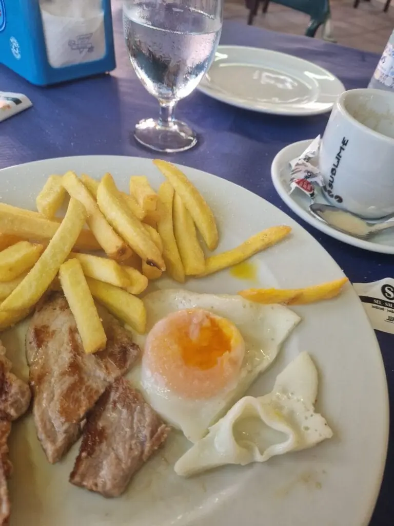 Desayuno con huevo frito, filete y patatas servido en La Victoria