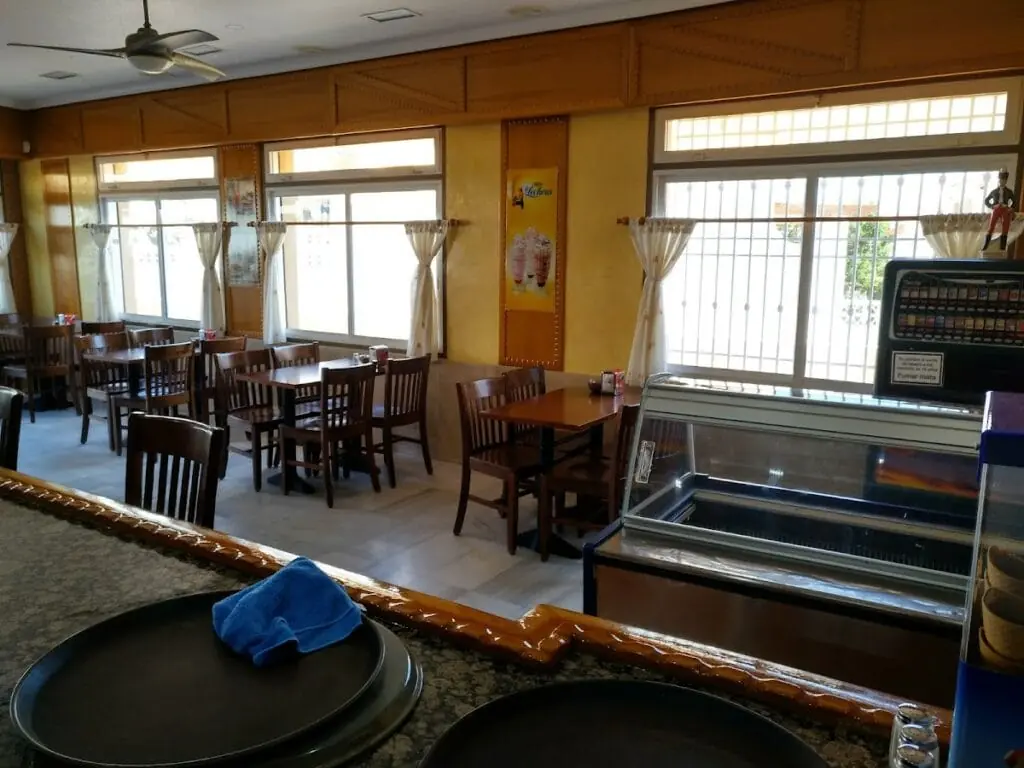 Salón interior de Cafetería Siglo XXI con mesas y vitrina