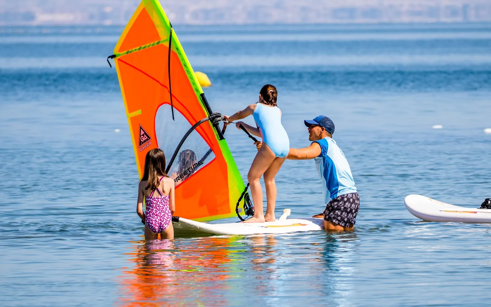 Monitor ayudando a una niña con windsurf en el Campus Náutico Dacar
