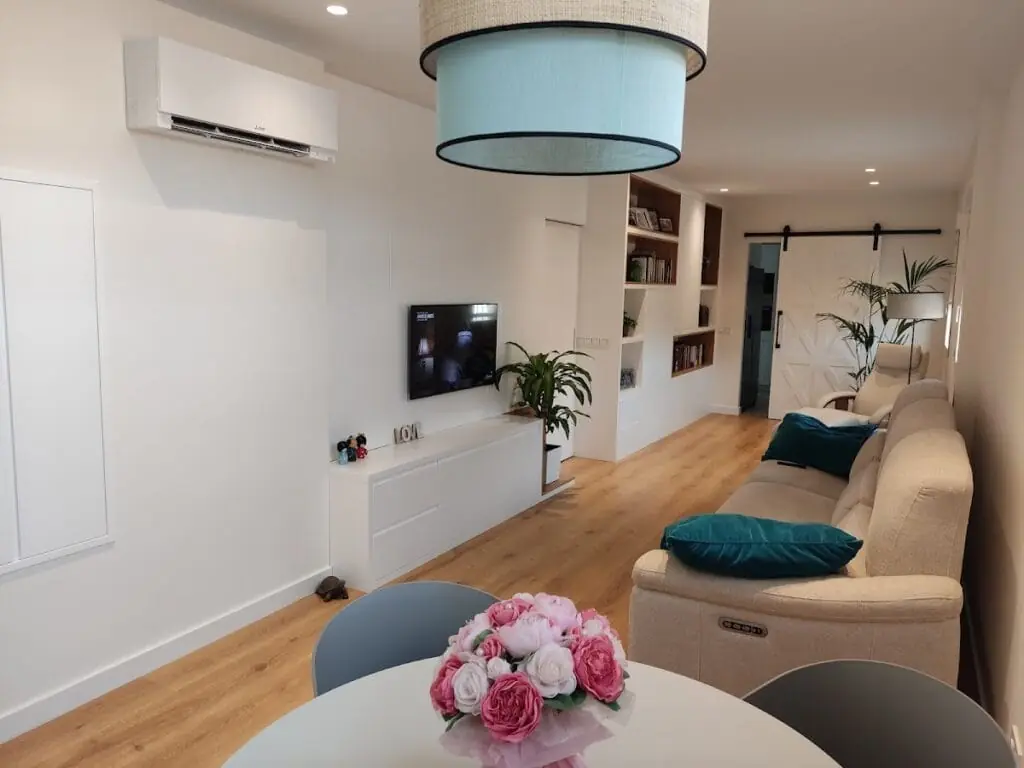 Salón con mueble de madera a medida y puerta corredera fabricados por Carpintería Laura Egea