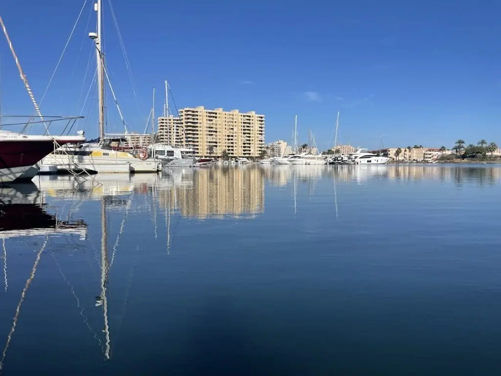 Veleros amarrados en el Club Náutico La Isleta, con el edificio residencial al fondo