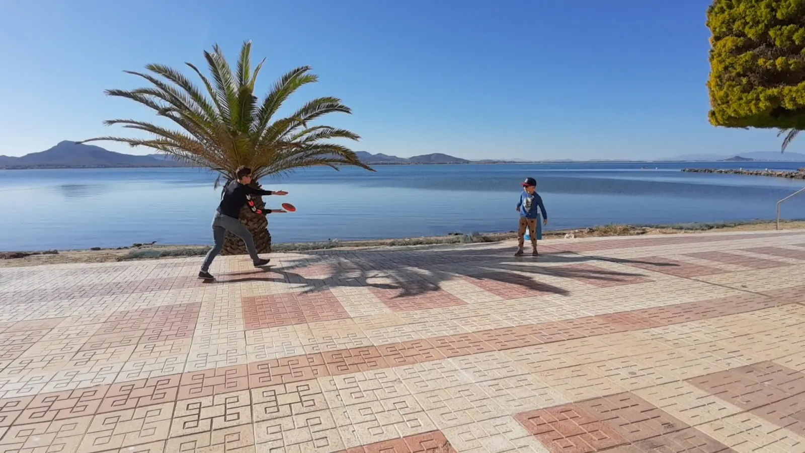 Paseo marítimo junto al Club Náutico La Isleta, con dos niños jugando