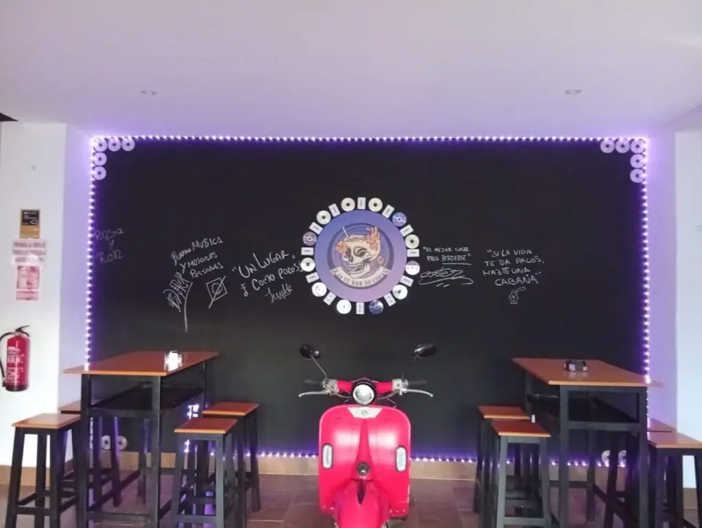 Pizarra decorativa con firmas de clientes y moto vespa en F-14 tu bar de copas