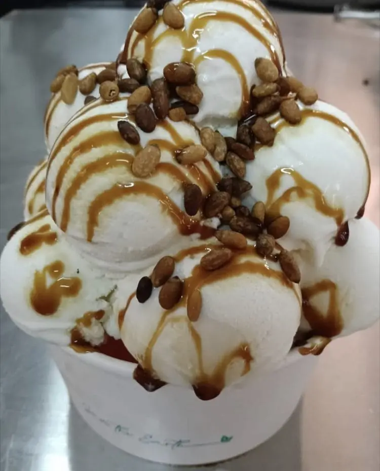 Tarrina de helado artesano con piñones y salsa de caramelo en Fábrica de Helado Artesano Verdú