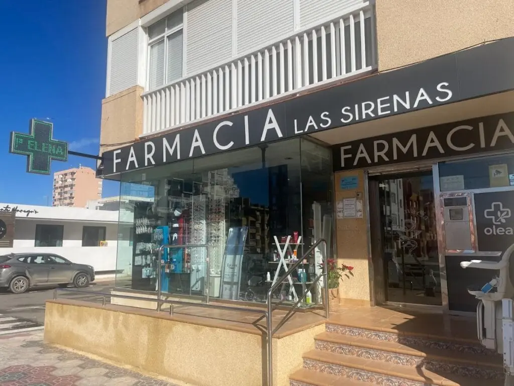 Fachada de Farmacia Las Sirenas con la cruz verde luminosa, en La Manga