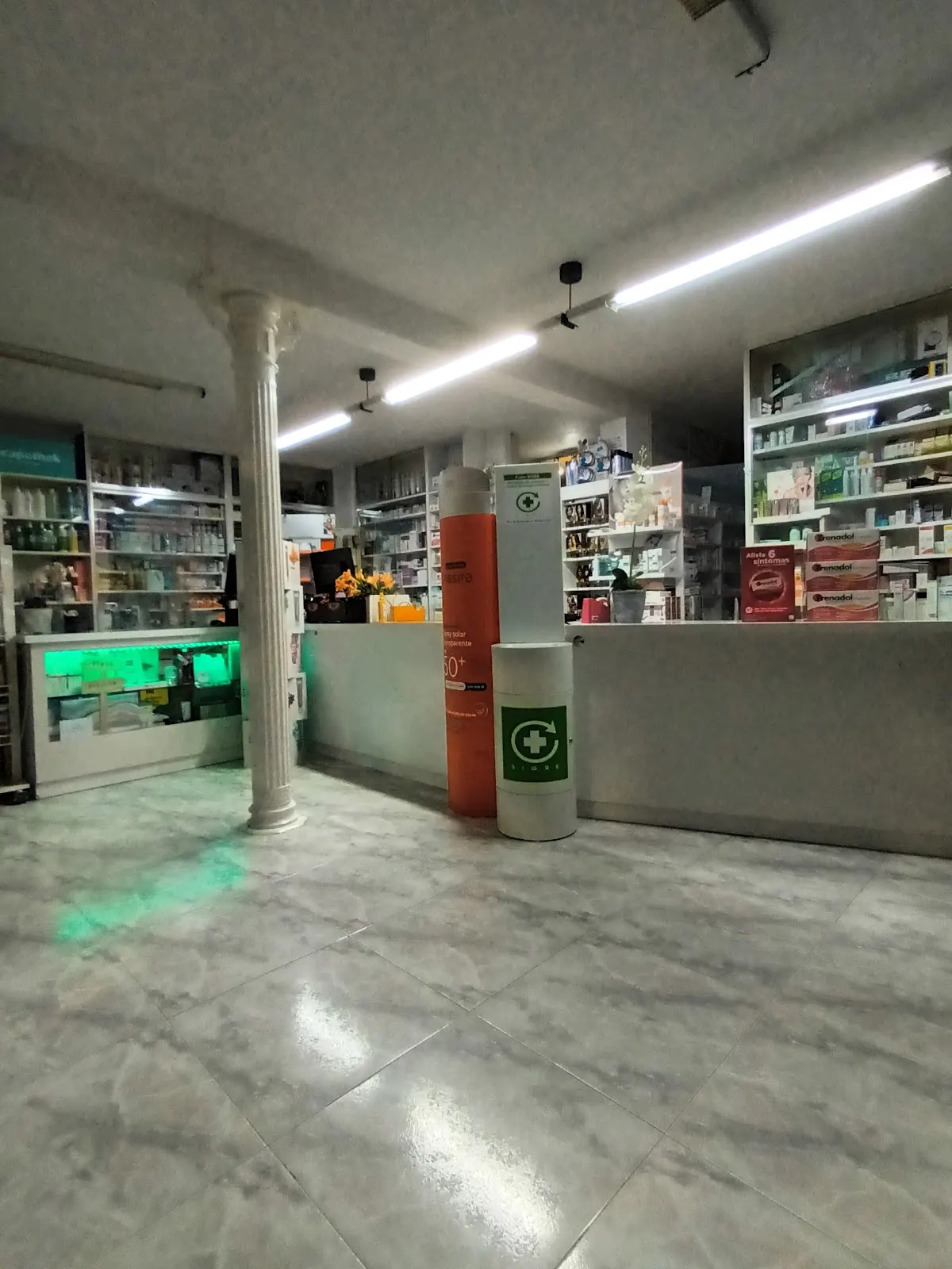 Interior de la Farmacia Nuevo Puerto Bello con columna clásica y expositores