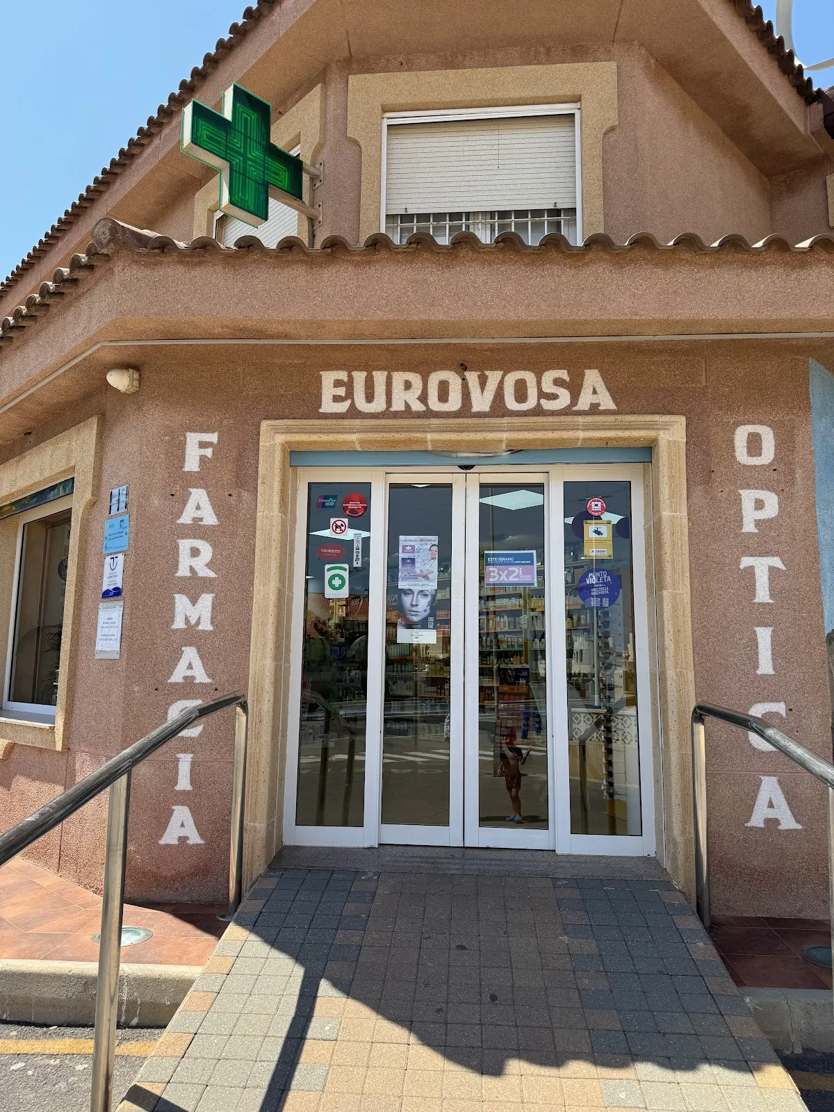 Entrada accesible de Farmacia Óptica Eurovosa con la cruz verde