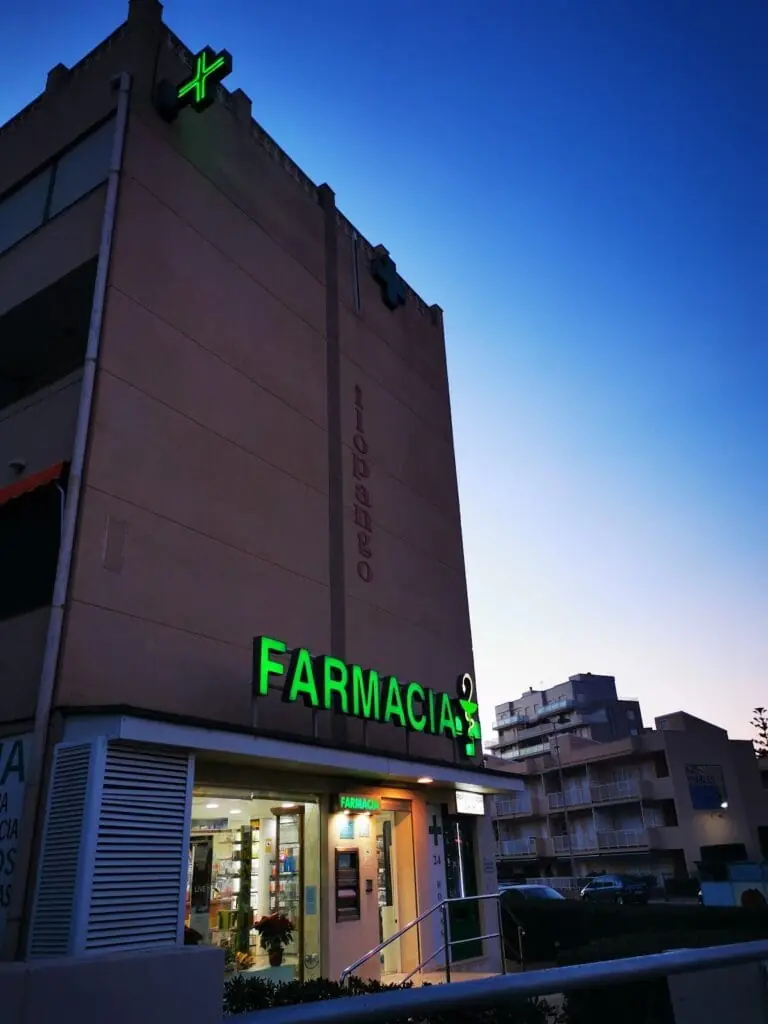 Fachada nocturna de Farmacia Plaza Bohemia con rótulo iluminado