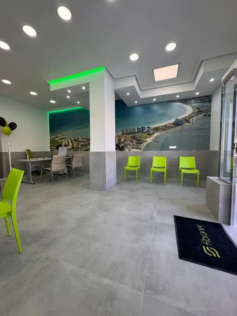 Interior de la tienda Fibranet La Manga, con sillas y mural del litoral de la Manga