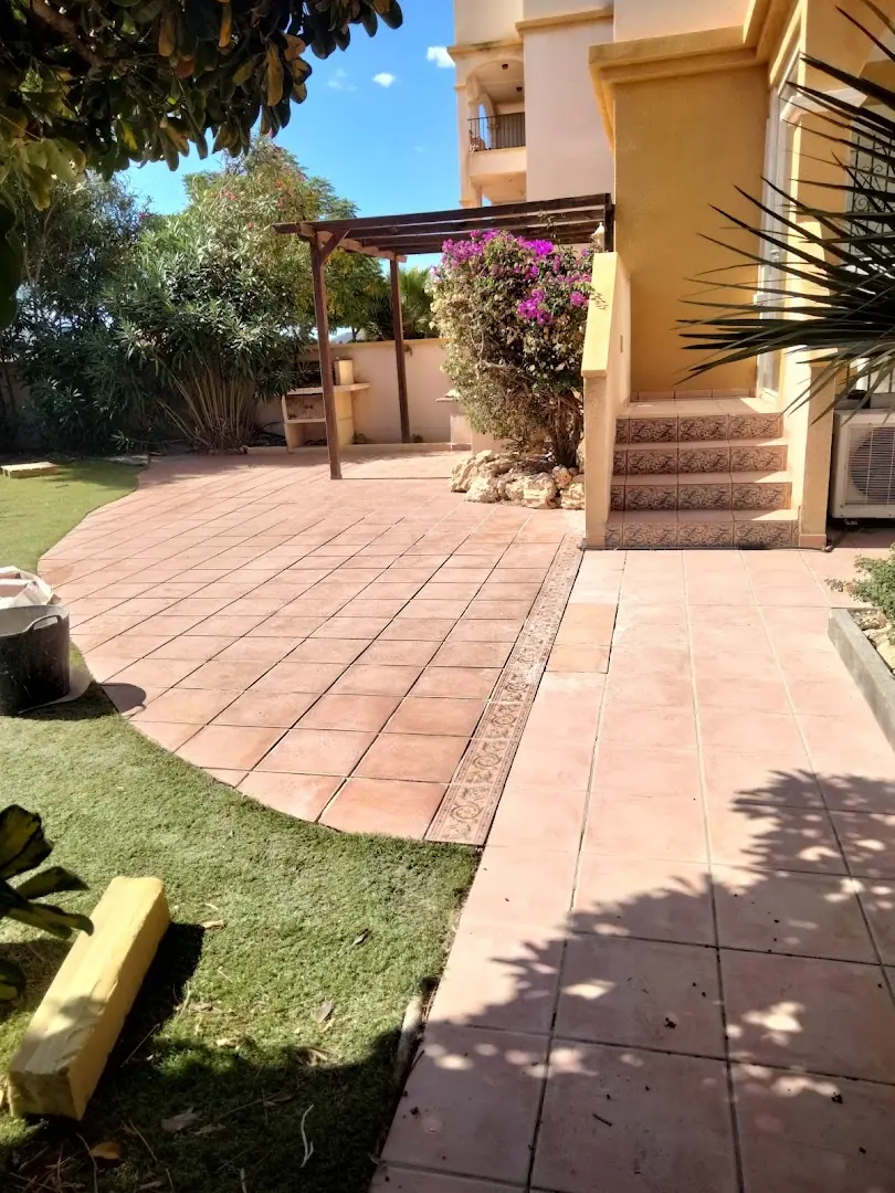 Jardín con césped y terraza mantenidos por Manga Clean