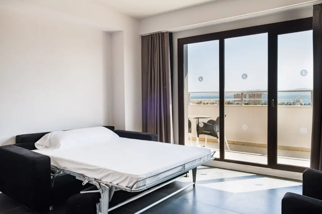 Habitación con sofá cama y balcón con vistas al mar en Hotel Bakour La Manga Splash