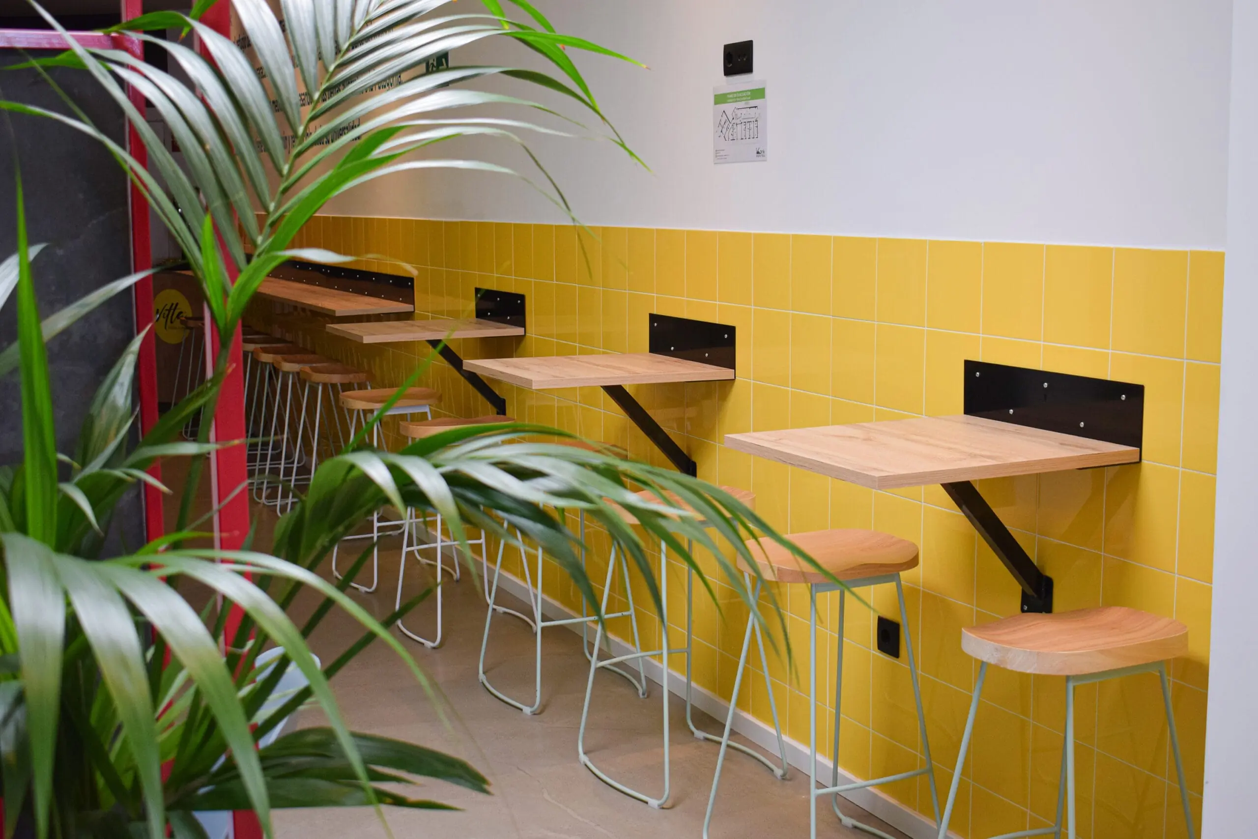 Zona común con mesas altas de Konk Hostel en La Manga del Mar Menor