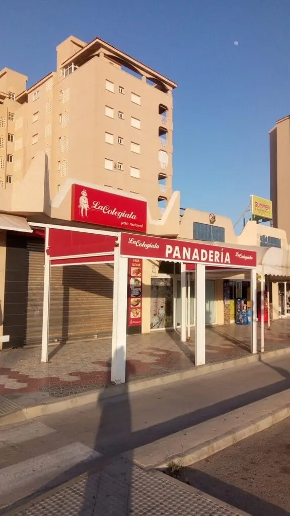 Vista de La Colegiala con su toldo rojo de panadería