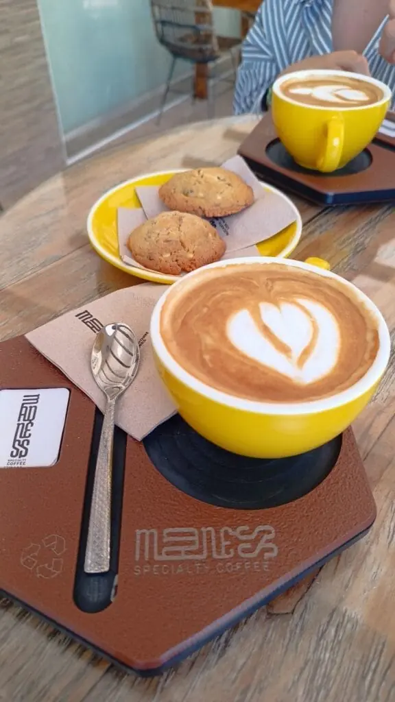 Café con arte latte y galletas servidos en Madness Specialty Coffee, Centro Comercial Mangamar