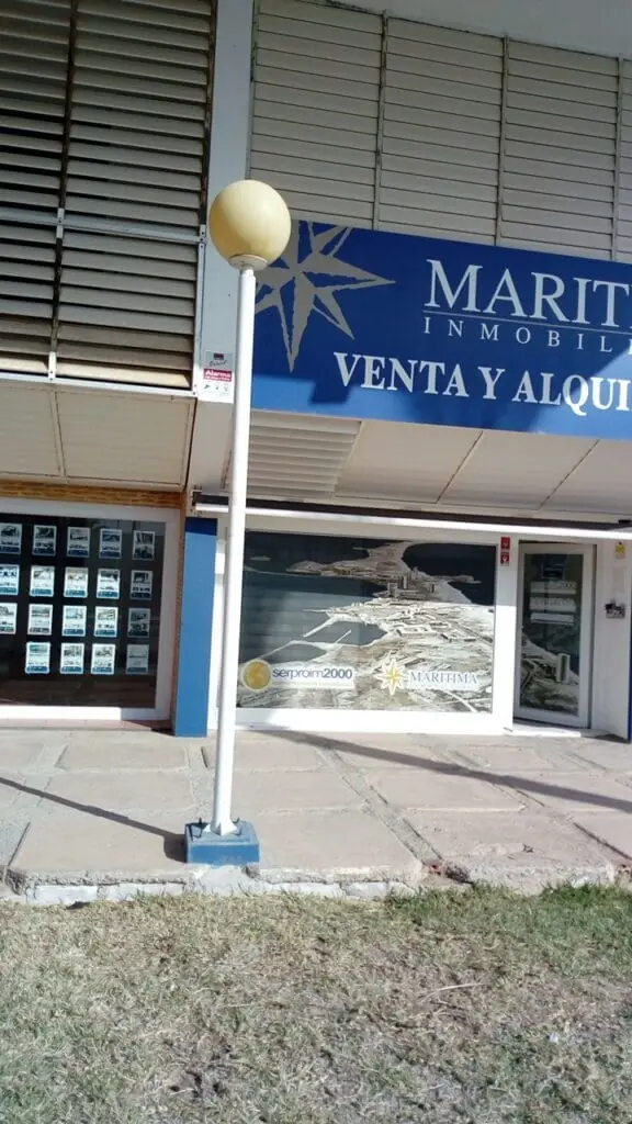 Fachada de la oficina de Marítima Inmobiliaria en Cabo de Palos, con el cartel de venta y alquiler