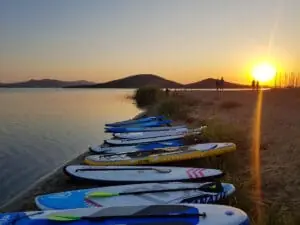 Tablas de paddle surf alineadas en la orilla al atardecer, Maskite