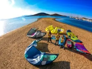 Grupo con material de kitesurf en la playa de Maskite