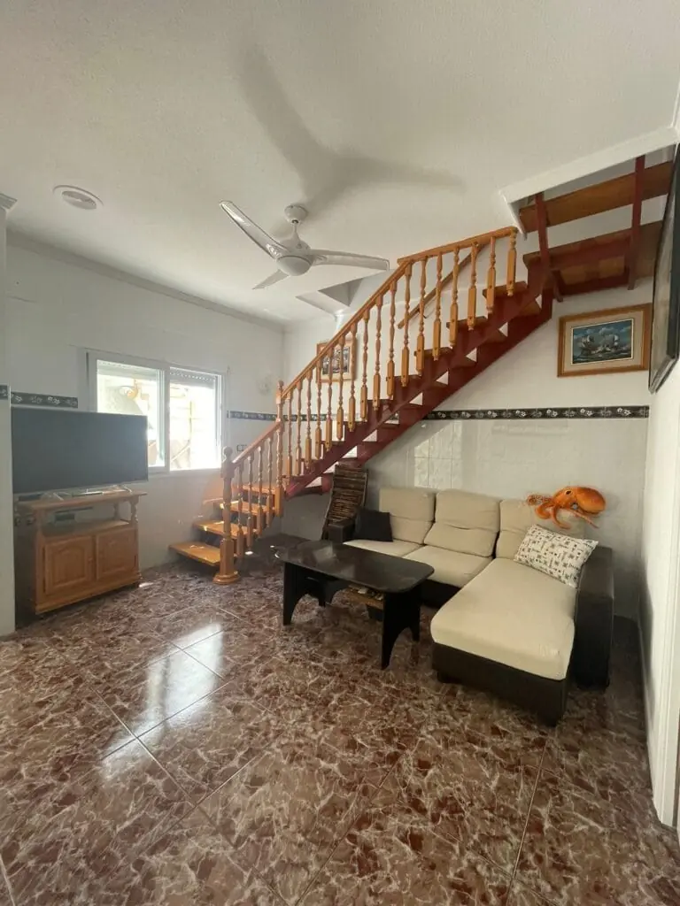 Salón con escalera de madera de Mero Habitaciones en Cabo de Palos