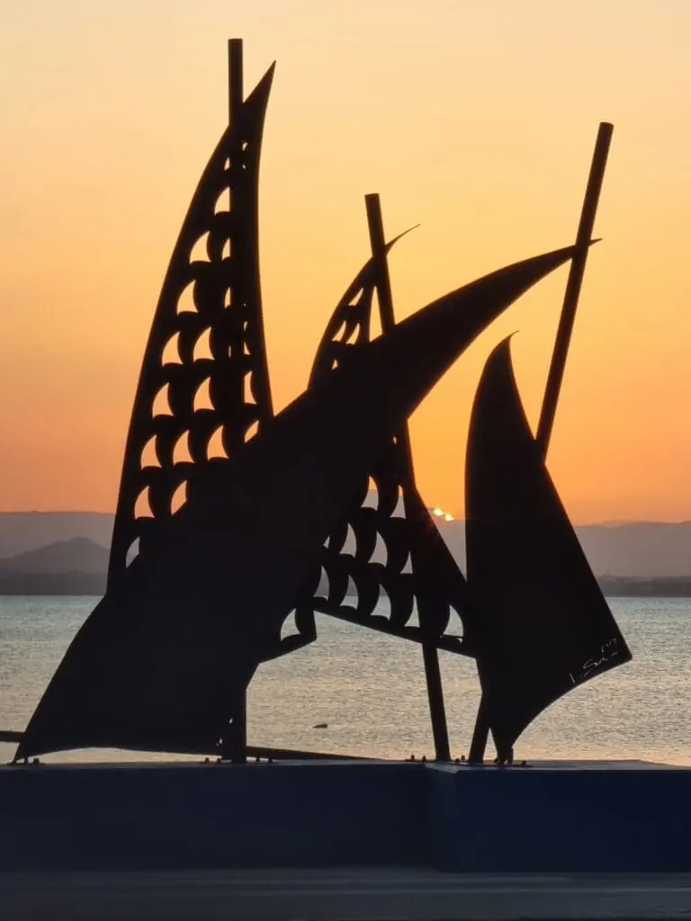 Escultura de velas metálicas del Monumento Velámenes al atardecer, La Manga