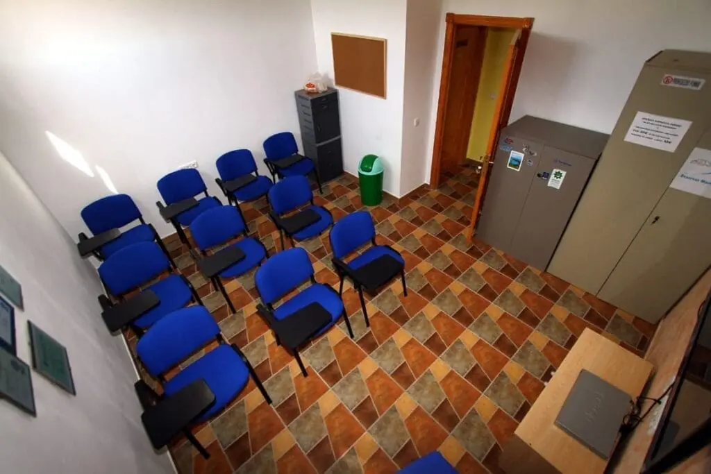 Aula de formación del centro de buceo Naranjito, con sillas y taquillas