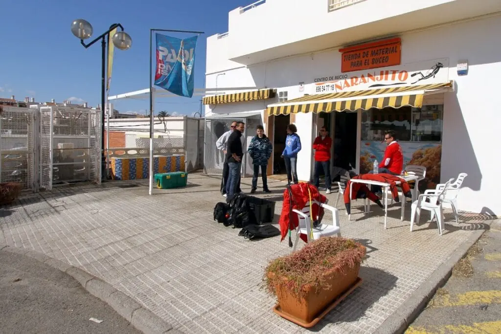 Fachada del centro de buceo Naranjito, con clientes preparando el equipo