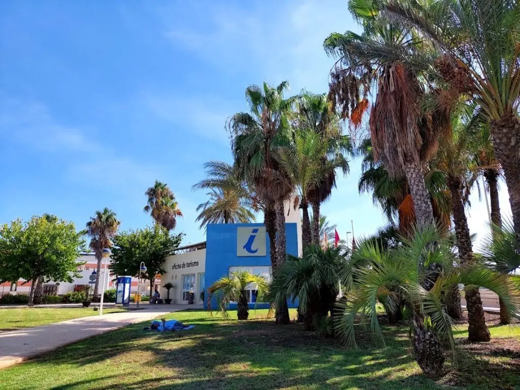 Edificio de la Oficina de Turismo de Cabo de Palos rodeado de palmeras, km 0 de la Gran Vía