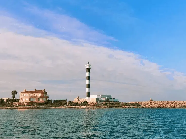 Embarcaciones cruzando el canal del Estacio junto al faro