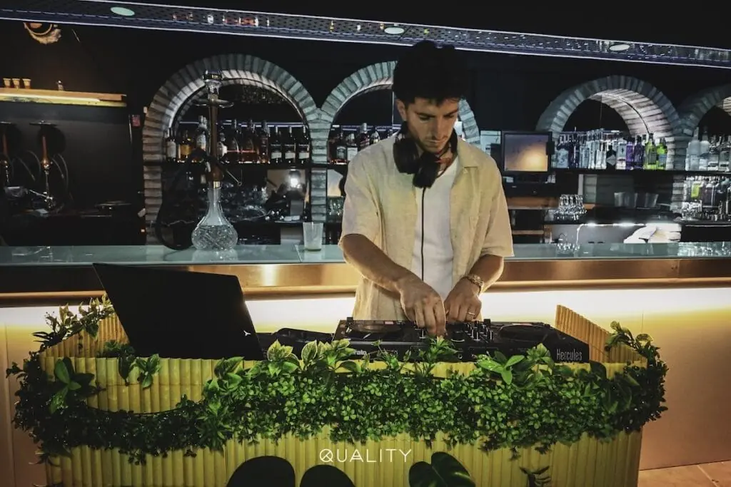 DJ playing by the bar at Quality Pub, with the booth beside the bar