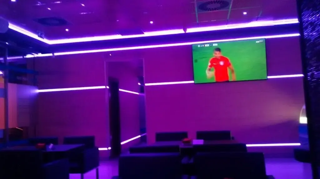 Interior de Sportbar Trébol con pantalla de fútbol y ambiente en tonos morados