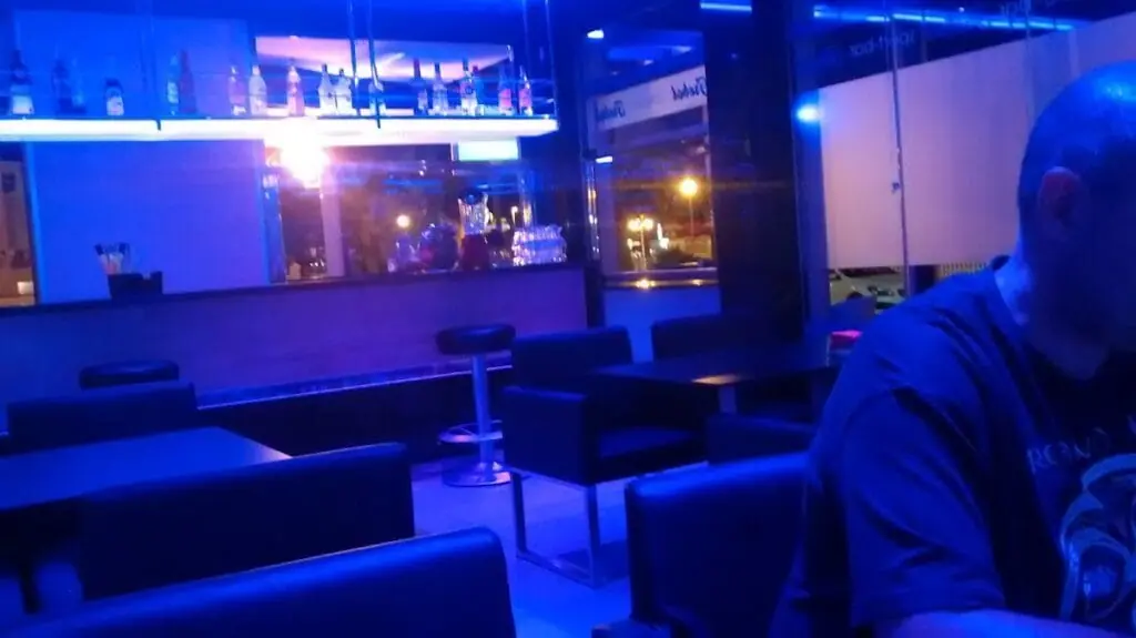 Zona de barra y mesas de Sportbar Trébol iluminada en azul