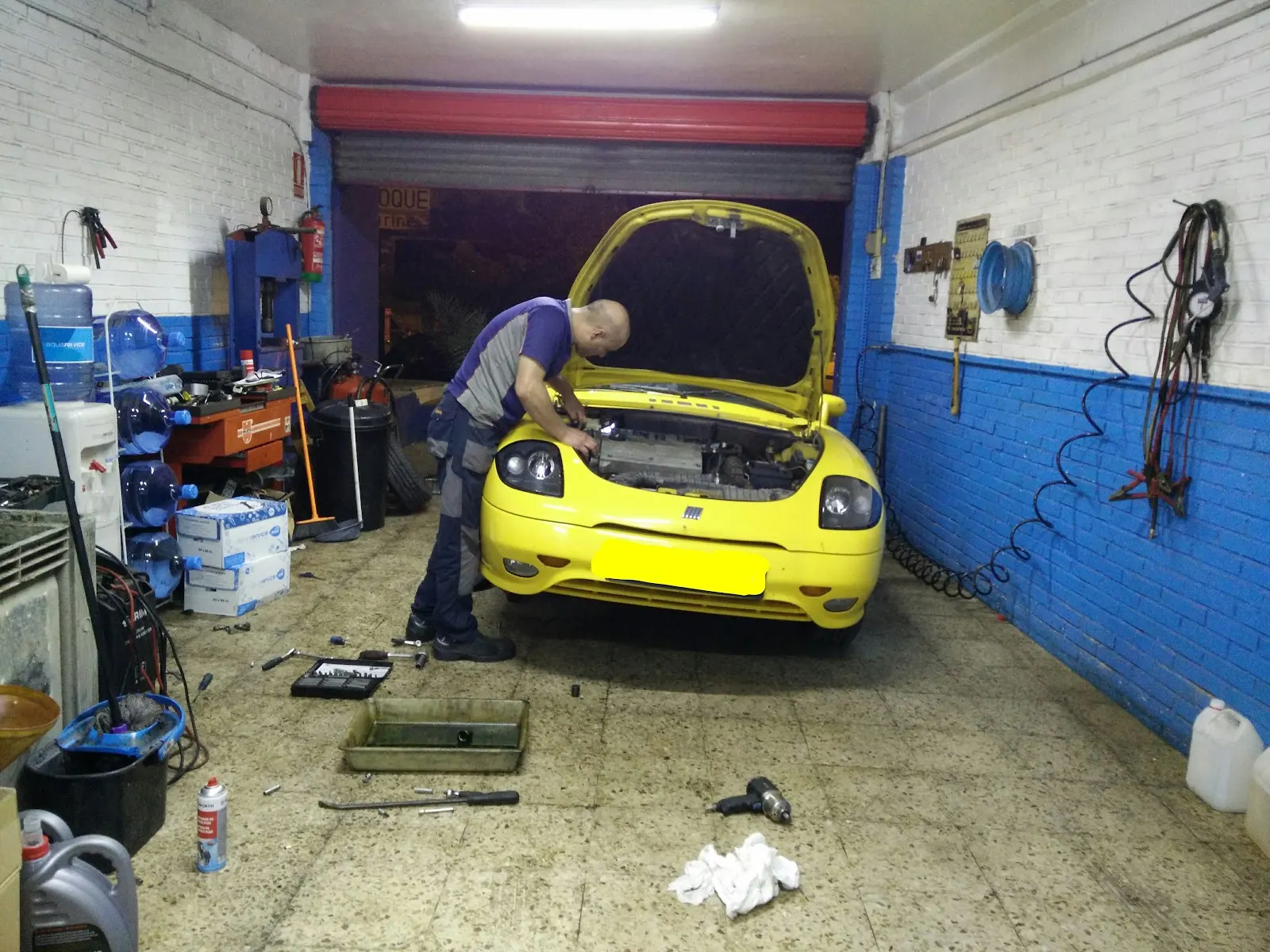Mecánico trabajando bajo el capó de un vehículo en Taller Francisco Javier Esteban