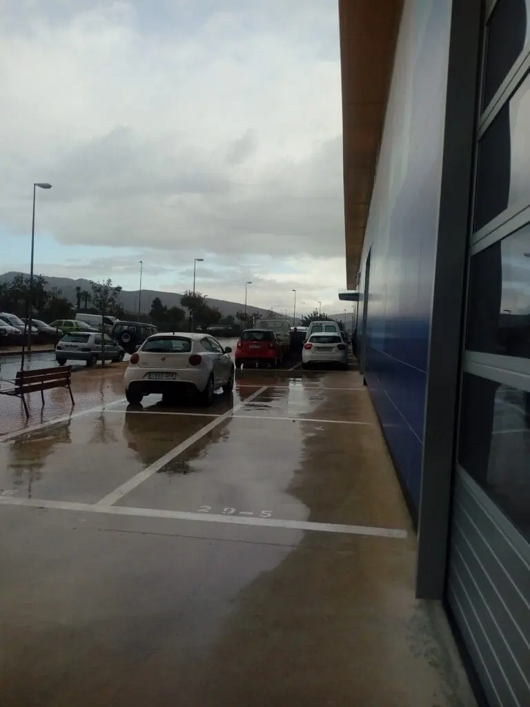 Aparcamiento junto al taller López Motor en un día de lluvia