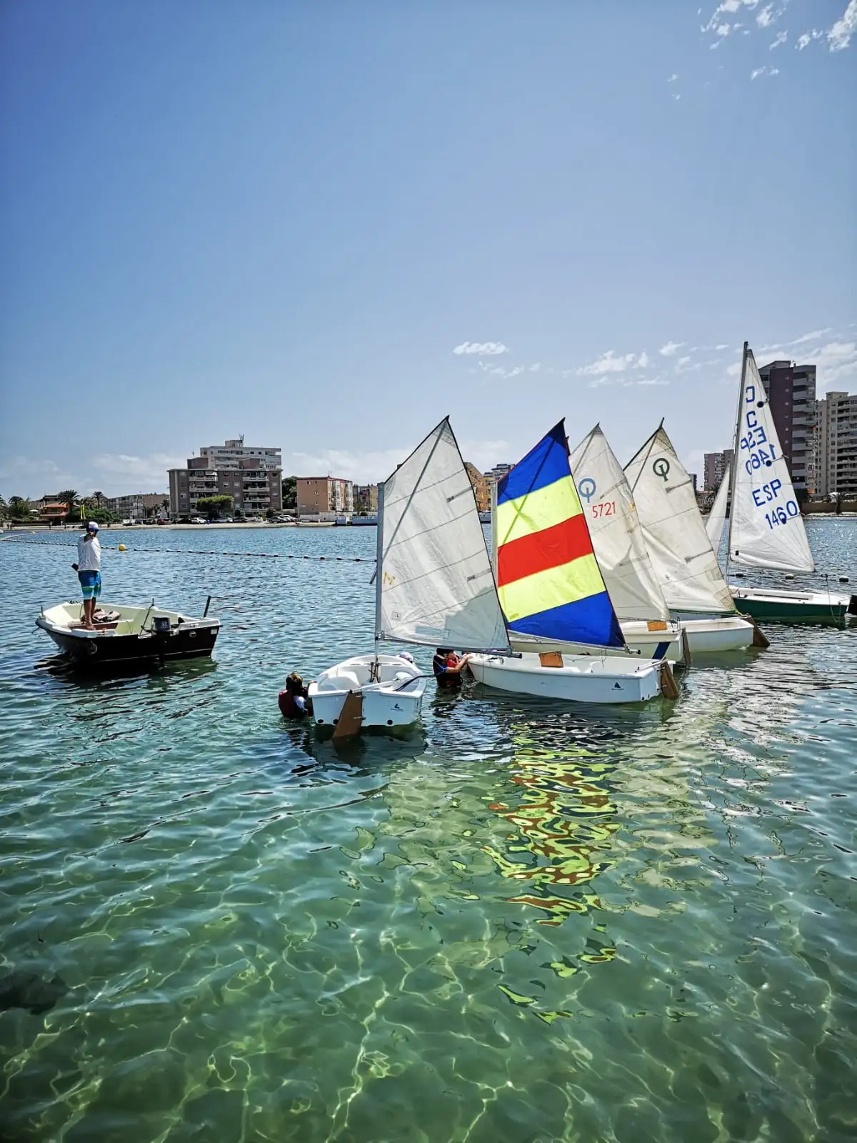Alumnos de Tatowind Sailing School preparando sus optimist en el Mar Menor